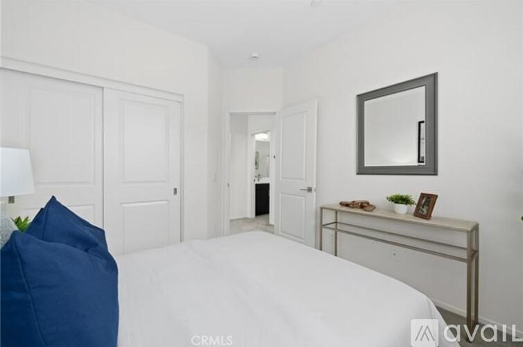 A bedroom with a white bed and a blue chair.