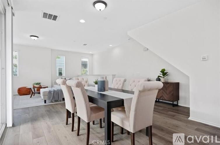 A modern dining room with a long table and chairs.