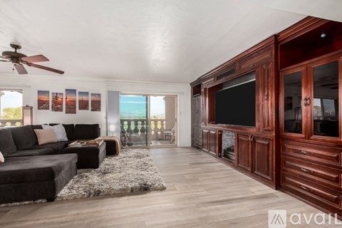 A living room with a black couch and a television.