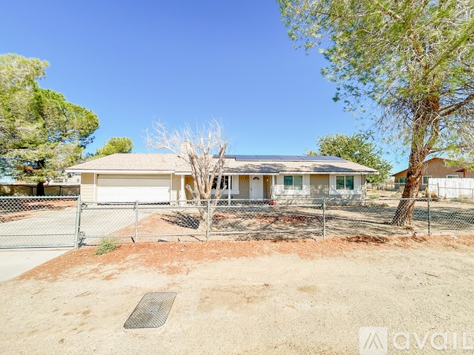 A house with a white fence and a tree in front of it.