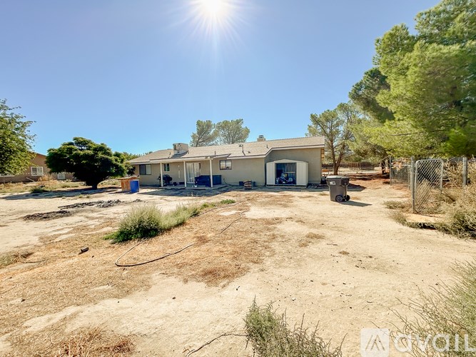 A house with a fence and trees in the background.