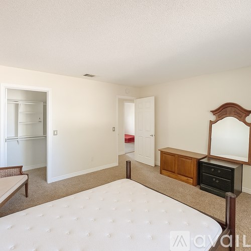 A bedroom with a bed, dresser, and mirror.