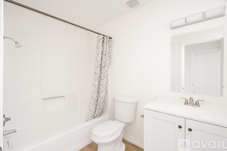 A white bathroom with a toilet, sink, and bathtub.