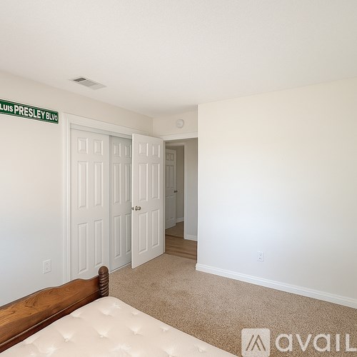 A bedroom with a bed and a door leading to another room.