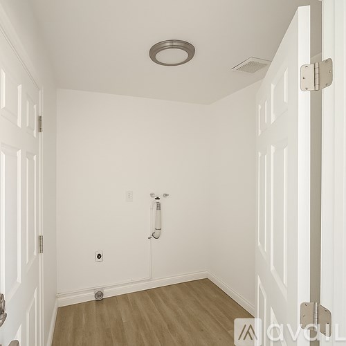 A white bathroom with a toilet paper holder and a towel rack.