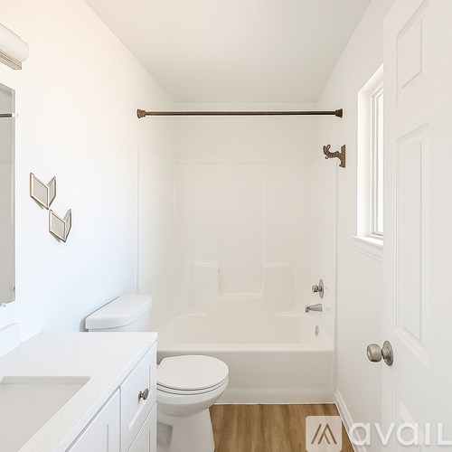 A white bathroom with a toilet, sink, and bathtub.