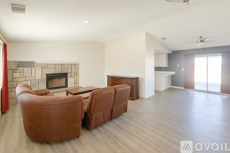 A living room with a fireplace and two brown leather chairs.