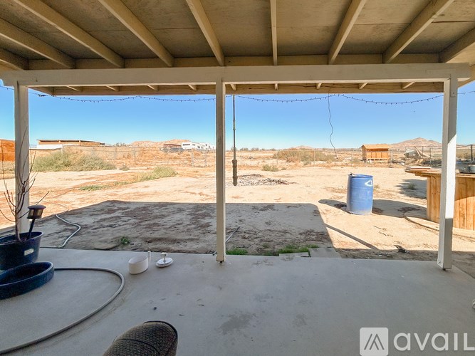 A patio with a table and chairs overlooking a desert landscape.