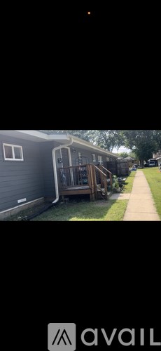 A grey house with a wooden deck.
