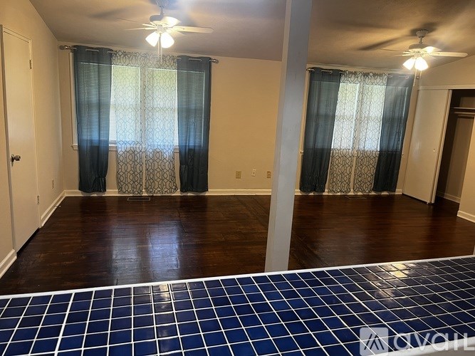 A room with a ceiling fan and a tile floor.