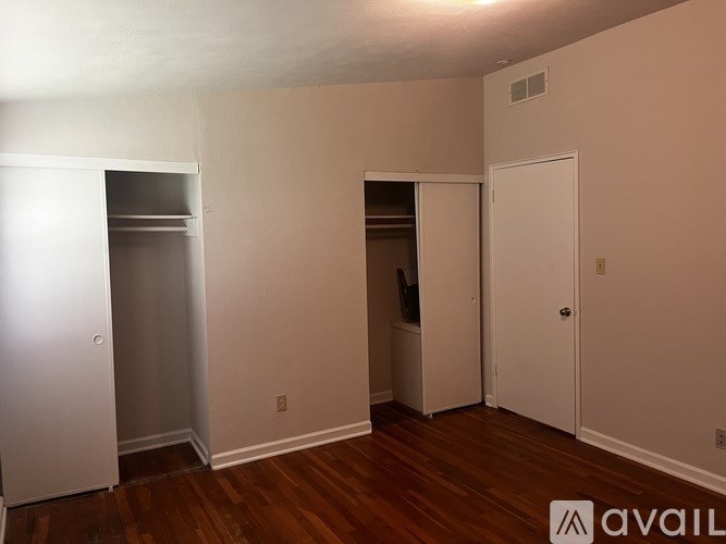 A room with a white door, a white closet, and a white wardrobe.