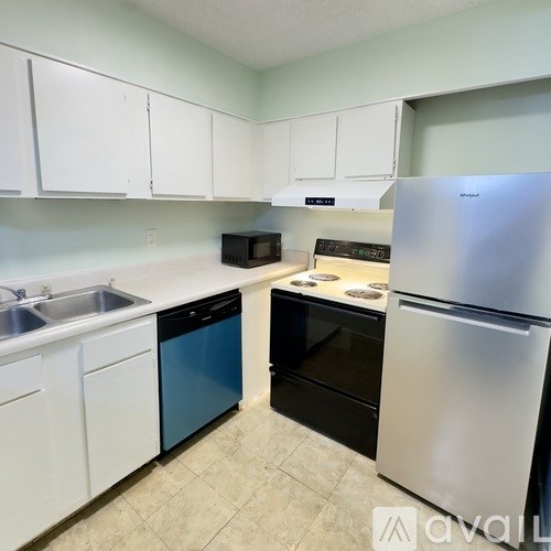 A kitchen with white cabinets and a stainless steel refrigerator.