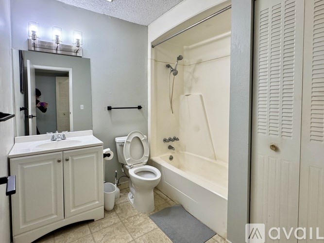 A bathroom with a toilet, sink, and bathtub.
