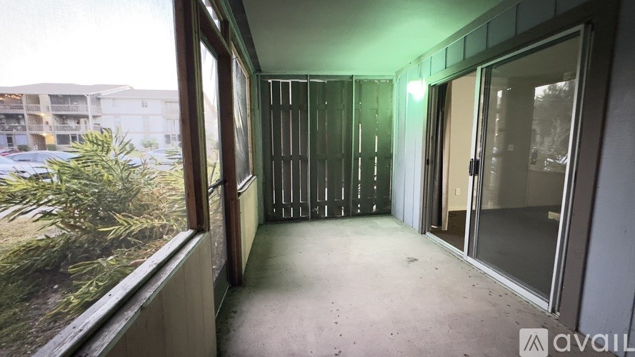 A room with a glass door and a window overlooking a parking lot.