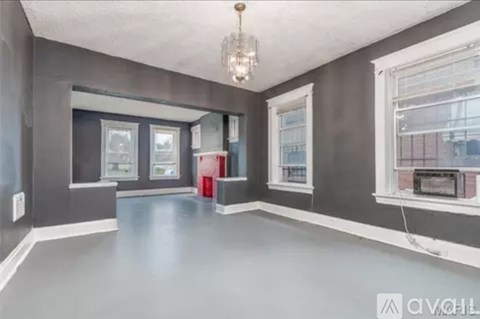 A room with grey walls and a chandelier hanging from the ceiling.