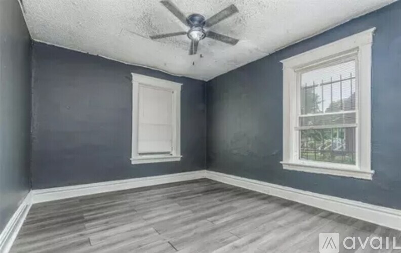 A room with a ceiling fan and a window.