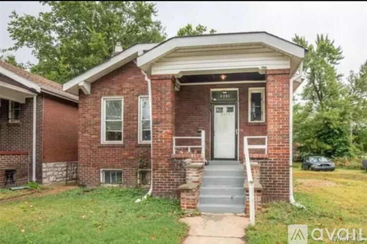 A brick house with a white door and a small porch.