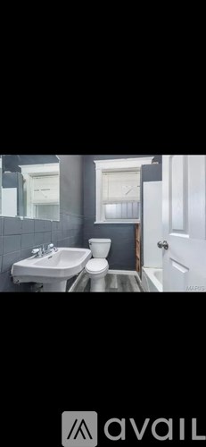 A bathroom with a toilet, sink, and mirror.