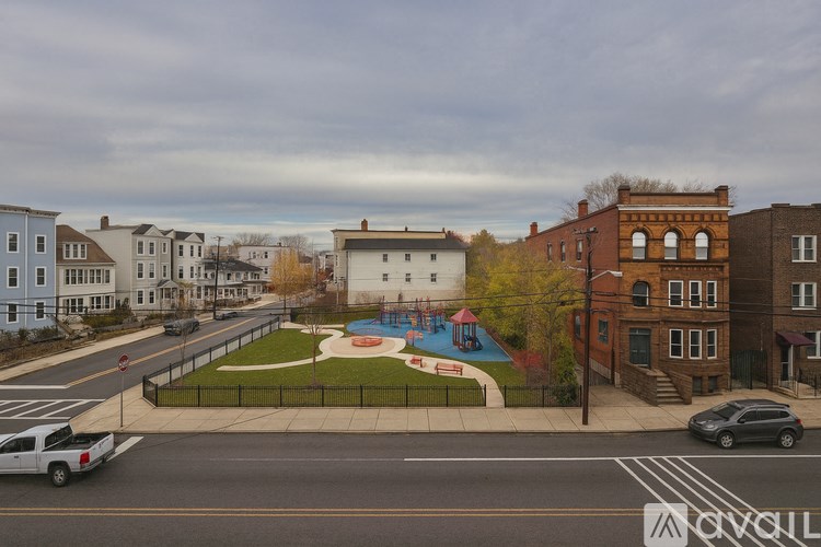 A view of a street with cars and a playground.
