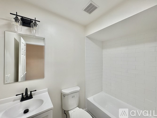 A white bathroom with a toilet, sink, and tub.