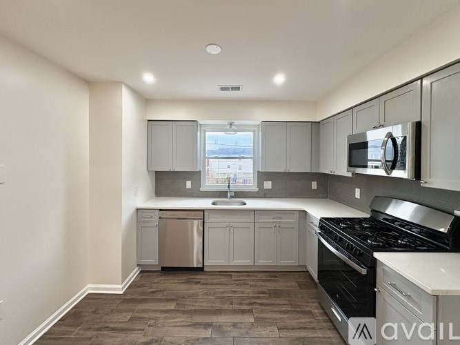 A kitchen with a black stove top oven and white cabinets.