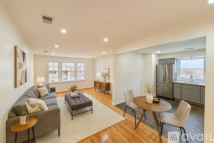 A living room with a grey couch, a coffee table, and a dining table with chairs.