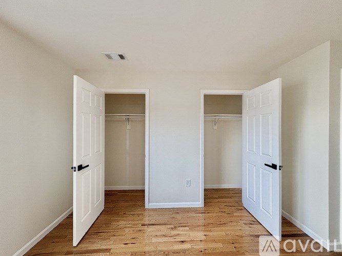 A room with two open doors and wooden flooring.