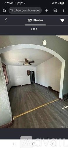 A room with a ceiling fan and wooden flooring.