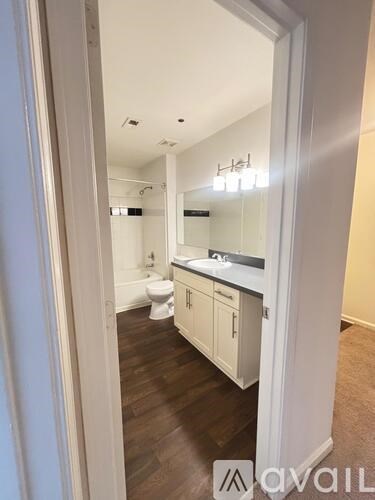 A bathroom with a toilet, sink, and mirror.