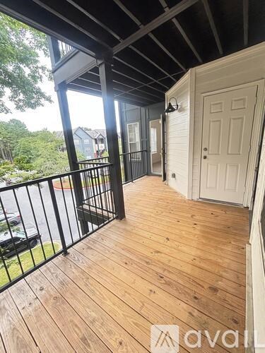 A balcony with a white door and black railings.