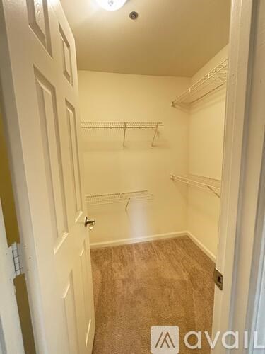 A room with a door and a wall-mounted shelf.