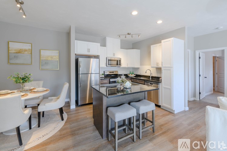 A modern kitchen with white cabinets and stainless steel appliances.