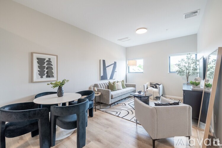 A living room with a white table and black chairs.