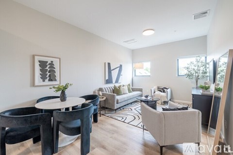 A living room with a white table and black chairs.