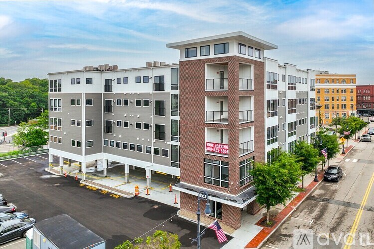 A multi-story building with a parking lot in front.