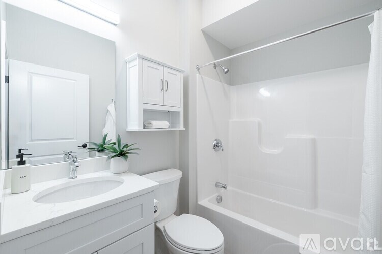 A white bathroom with a toilet, sink, and bathtub.