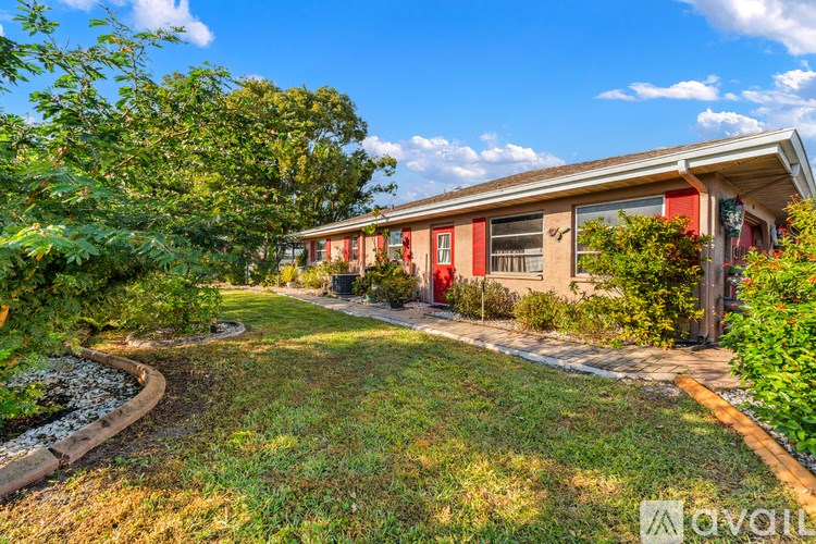 A house with a red door and a garden in front.