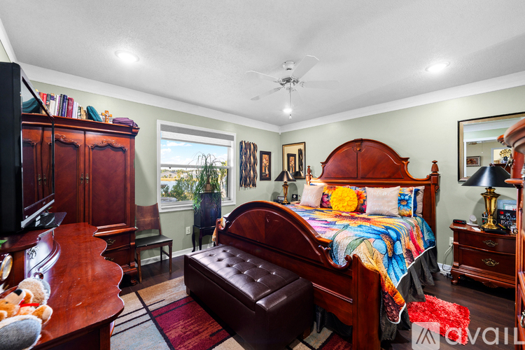 A bedroom with a bed, dresser, and chair.