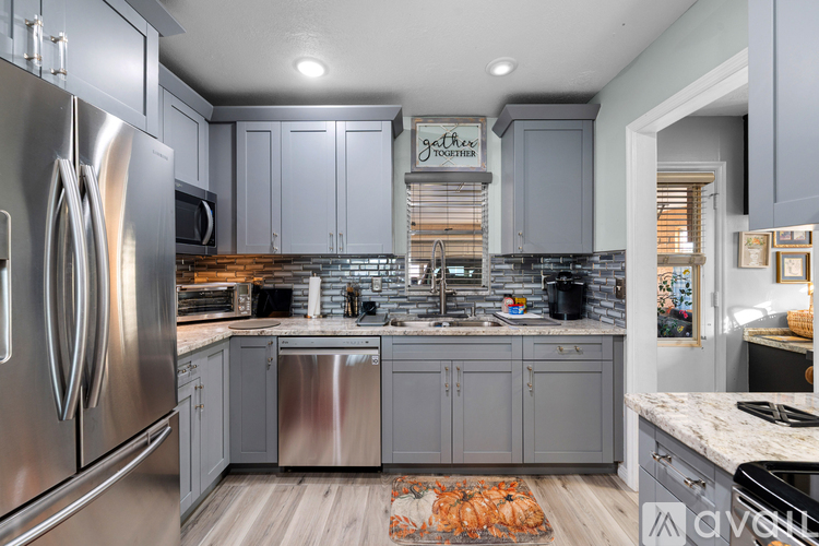 A kitchen with a stainless steel refrigerator and cabinets.