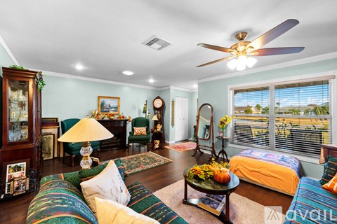 A living room with a ceiling fan and a bed.
