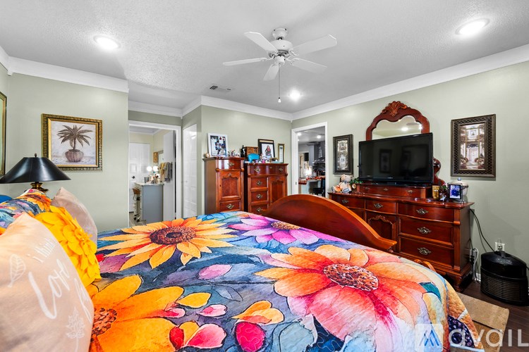 Bedroom with a bed, dresser, and television.