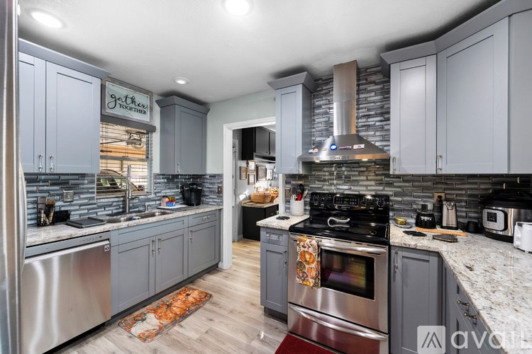 A kitchen with a stove top oven and a sink.