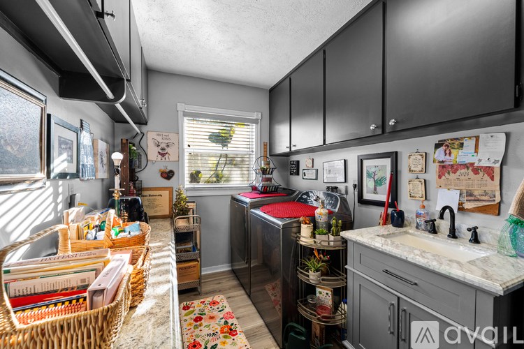 A kitchen with a sink, cabinets, and a window.