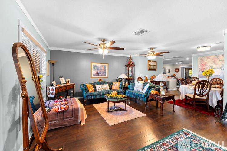 A living room with a wooden floor and a ceiling fan.
