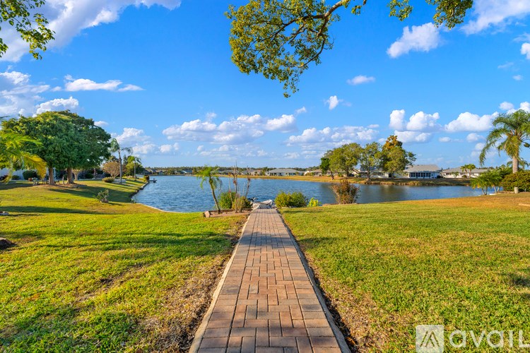 A walkway leads through a grassy area to a body of water.