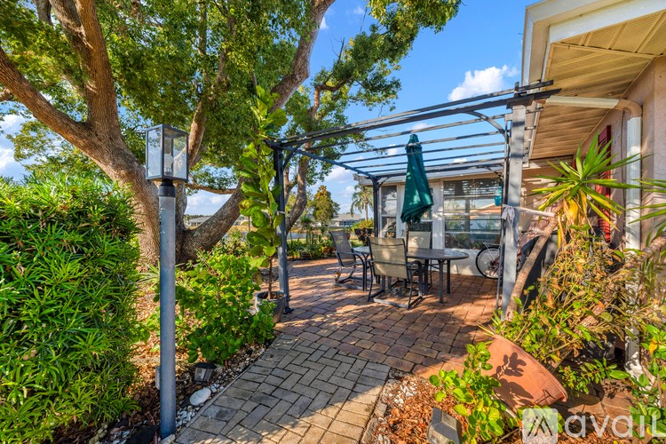 A patio area with a table and chairs under a pergola.