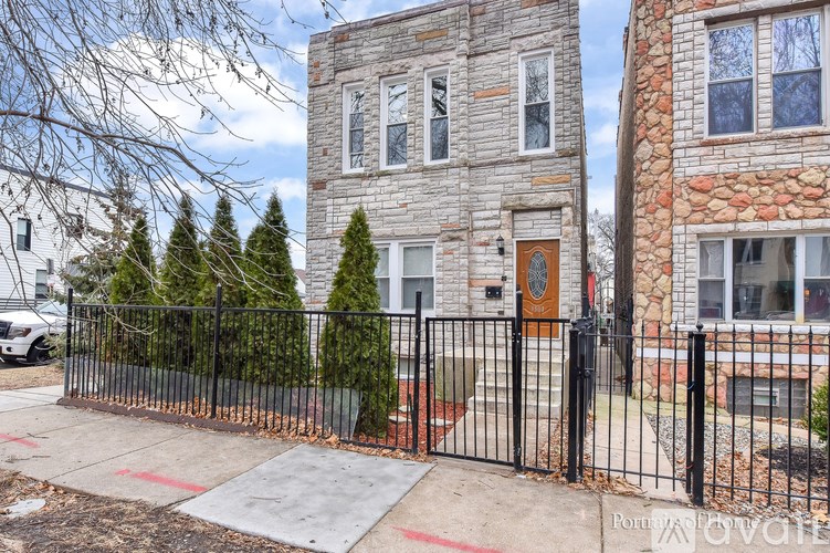 A house with a black fence and a brown door.