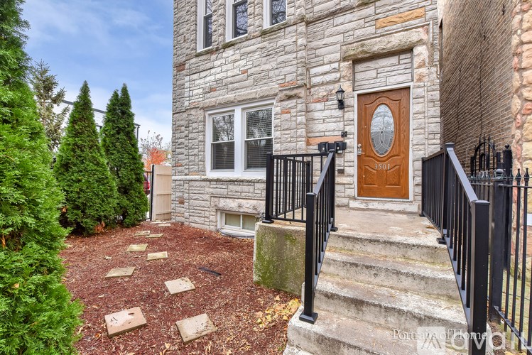 A house with a brown door and a black railing.