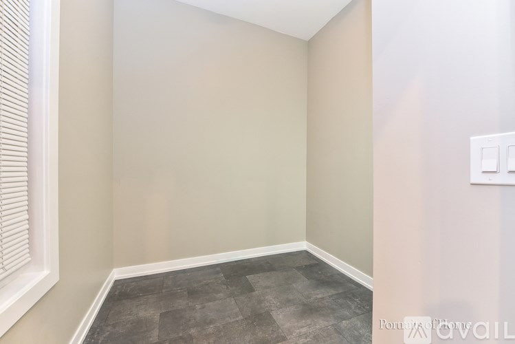 A room with a window on the left and a light switch on the right.