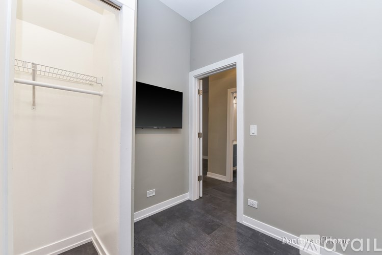 A room with a walk in closet and a doorway leading to another room.